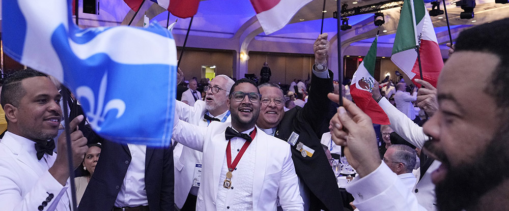 State Deputy Manuel Tom&aacute;s Tejeda S&aacute;nchez of the Dominican Republic (center) and others wave their jurisdictions&rsquo; flags during the annual States Dinner on Aug. 5.
