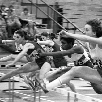 Athletes leap over hurdles during a race at the 1981 K of C Saskatoon Indoor games. 