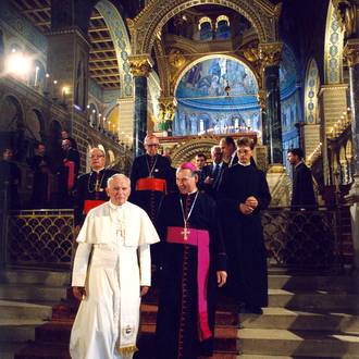 Pope John Paul II Stands with a group of Cardinals inside of a Hungarian Cathedral.