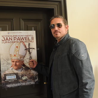 Catholic actor Jim Caviezel poses in front of the poster for the Polish tour of Knights-created Liberating a Contintent film.