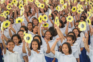 Students wave paper flowers during the Supreme Council delegation’s Aug. 21 visit to Girlstown
