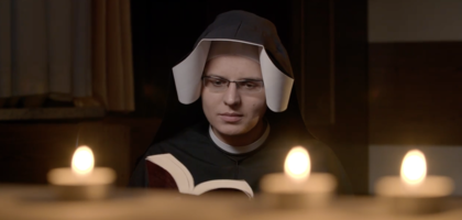 Sister reads in front of candles.