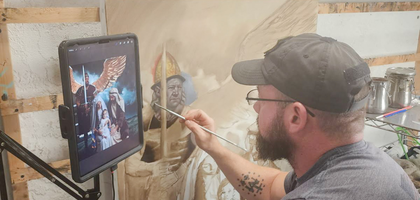 Tony Suppa, an artist and member of Father John J. Walsh Council 7052 in Venice, Fla., paints a portrait of the Holy Family being guarded by St. Michael the Archangel. 