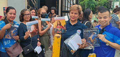 Deputy Grand Knight Nilo Sarmiento of Banal na Sakramento Council 8753 in Quezon City, Luzon North, gifts past issues of Columbia to Banal na Sakramento parishioners who attended a community caravan organized by Banal na Sakramento Parish’s Social Action Ministry.