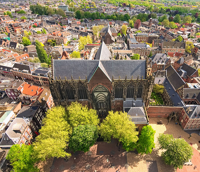 Aerial view of a gothic church in a community crowded with buildings.