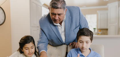 A father helps children with homework.