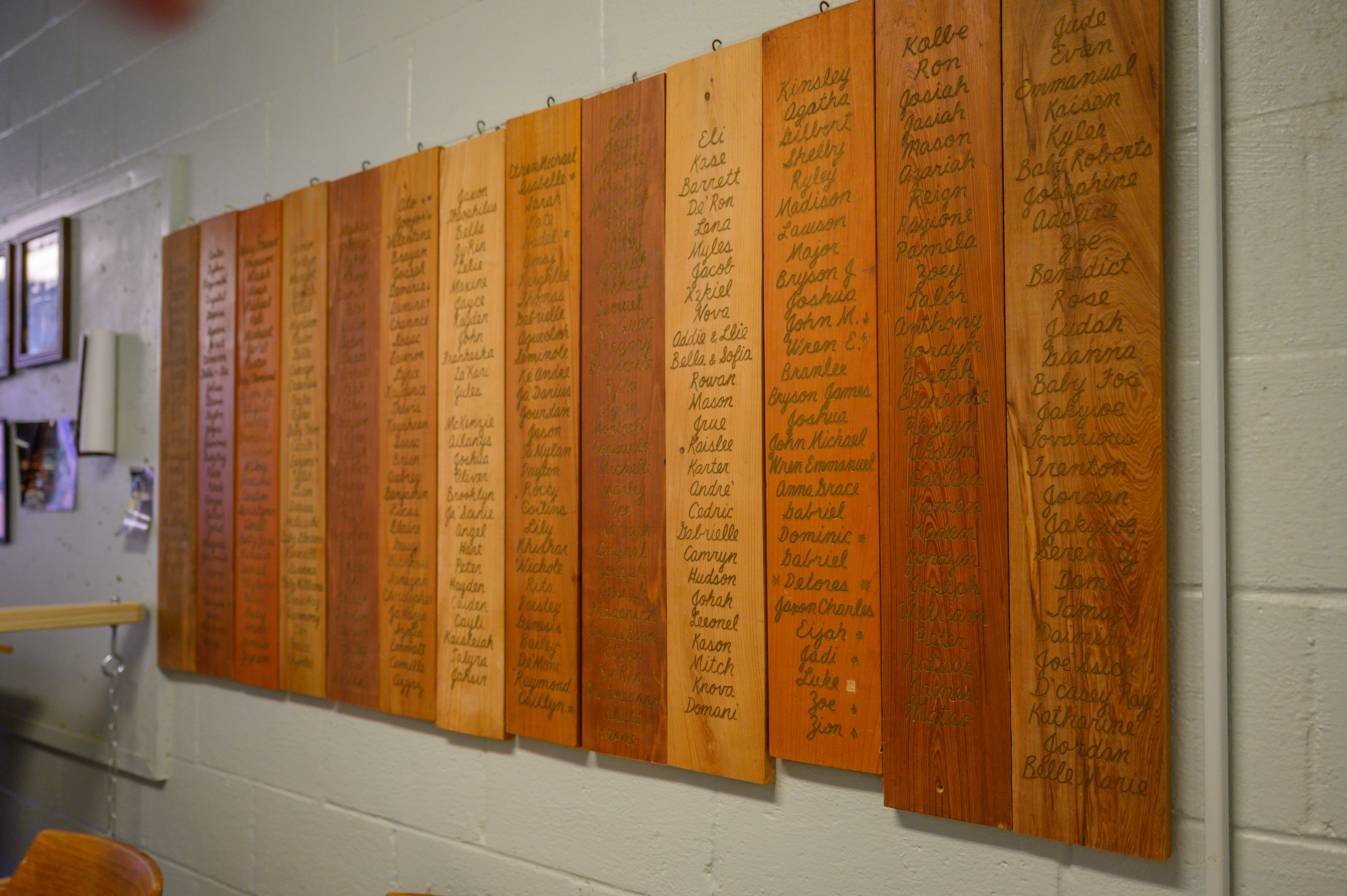 Wooden panels bearing the names of every child who has received a casket from All God&rsquo;s Babies hang in the organization's workshop.