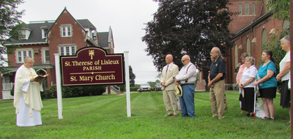 Father David Choquette, pastor and council chaplain for Cargill Council 64 in Putnam, Conn., blesses the new exterior sign for St. Thérèse of Lisieux Parish at St. Mary Church, as the previous one had blown away during a winter storm three years ago. The sign was commissioned and funded by the council and its associated women’s group. The sign blessing followed a Mass, which was part of the council’s 133rd anniversary celebration. The event also included a memorial prayer service at the grave of the council’s charter grand knight, Edward Mullan, at St. Mary Cemetery.