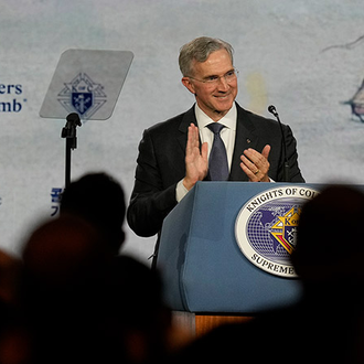 Supreme Knight Patrick Kelly leads applause during the Aug. 6 business session of the 142nd Supreme Convention in Québec City.