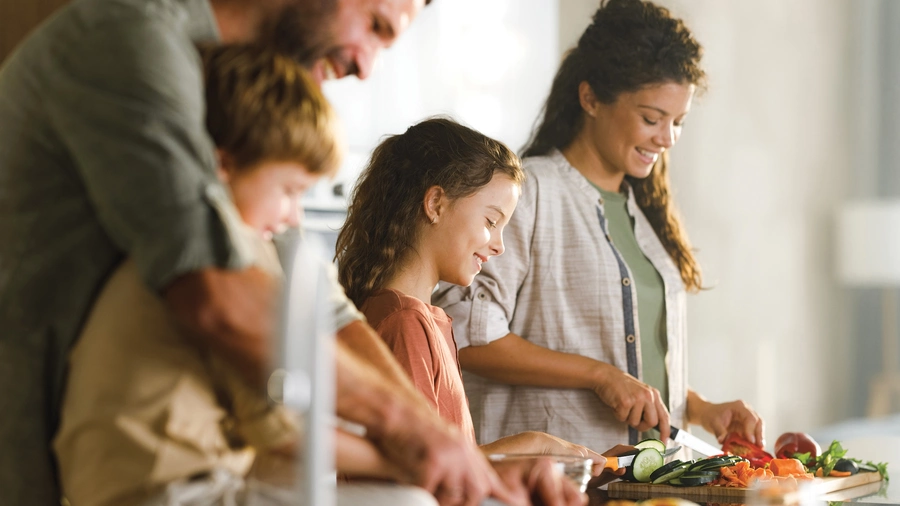 Happy family preparing healthy meal in the kitchen.