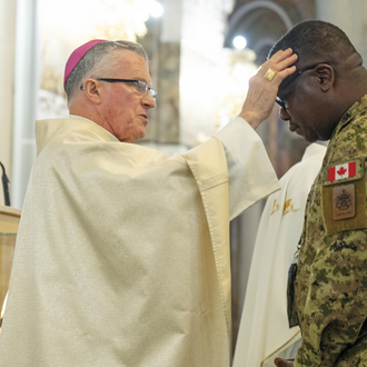 Archbishop Broglio anoints a Canadian service member during the opening Mass for the Warriors to Lourdes pilgrimage.