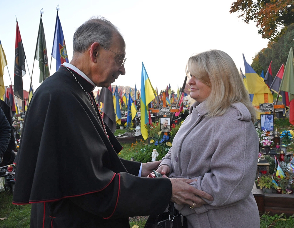 Archbishop Lori seeks with a women in a cemetery in Ukraine