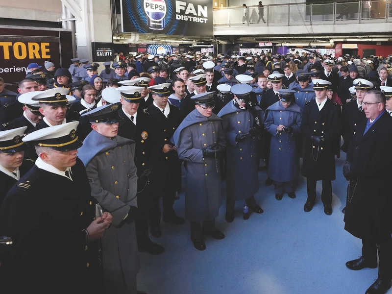 Supreme Master Michael McCusker, cadets, midshipmen and others pray the rosary during halftime of the annual Army-Navy football game.