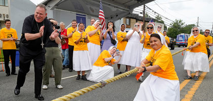 Bishop Kevin Sweeney of Paterson, N.J., cheers on religious sisters competing in a tug of war event.