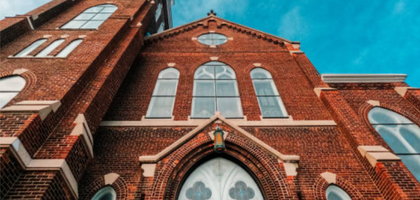 A brick church is seen from the outside.