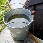 Metal bucket at draw-well in European village.