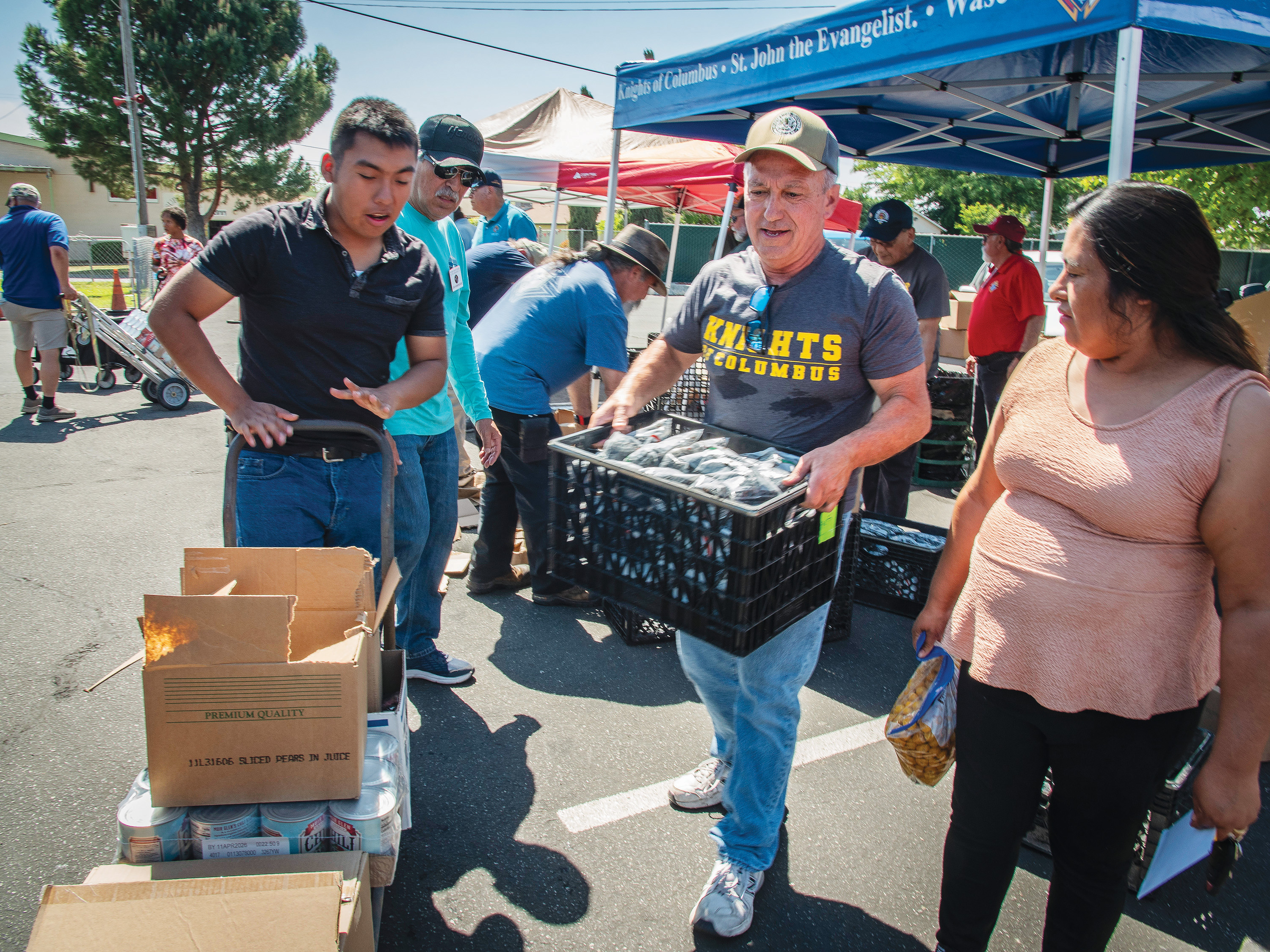 Past Grand Knight Mark Nazeck of Father John Crowley Council 3199 in Ridgecrest, Calif., helps carry food to a family&rsquo;s car during the March 28 event.