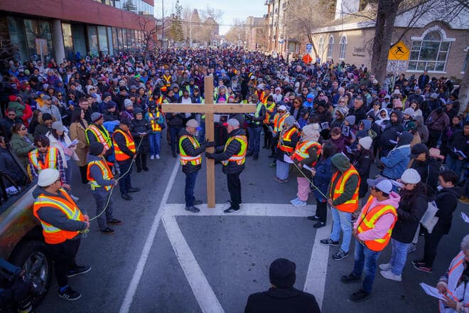 Knights from several councils in Calgary, Alberta, hold a cross and rope during an outdoor Way of the Cross procession.