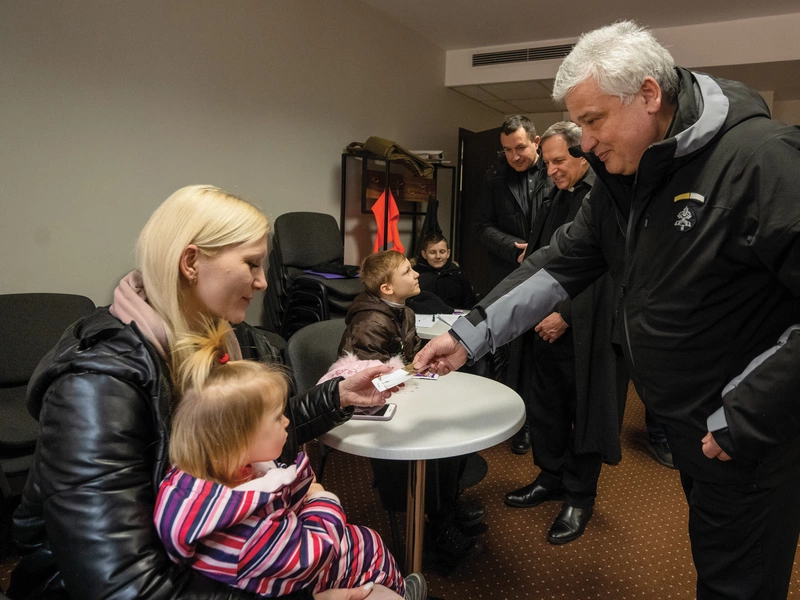 Cardinal Konrad Krajewski greets a Ukrainian woman and child during a humanitarian visit in March 2022.