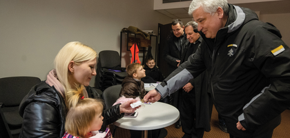 Cardinal Konrad Krajewski greets a Ukrainian woman and child during a humanitarian visit in March 2022.