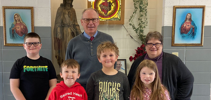 Richard Braun, a member of Msgr. Condon Council 3805 in Reedsburg, Wis., presents a check for nearly $900 to Principal Karen Marklein and students from Sacred Heart School.