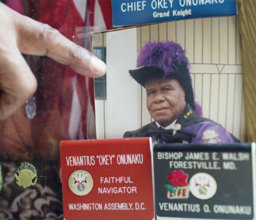 Chief Onunaku in Knights regalia surrounded by badges