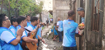 Members of Mary the Queen Council 18617 in Virac, Luzon South, present food to a community member while serenading her with Christmas carols during the council’s recent door-to-door distribution. 