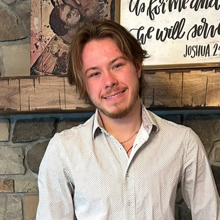 Ciaran Walsh smiles for photograph with Joshua 24:15 quote in background