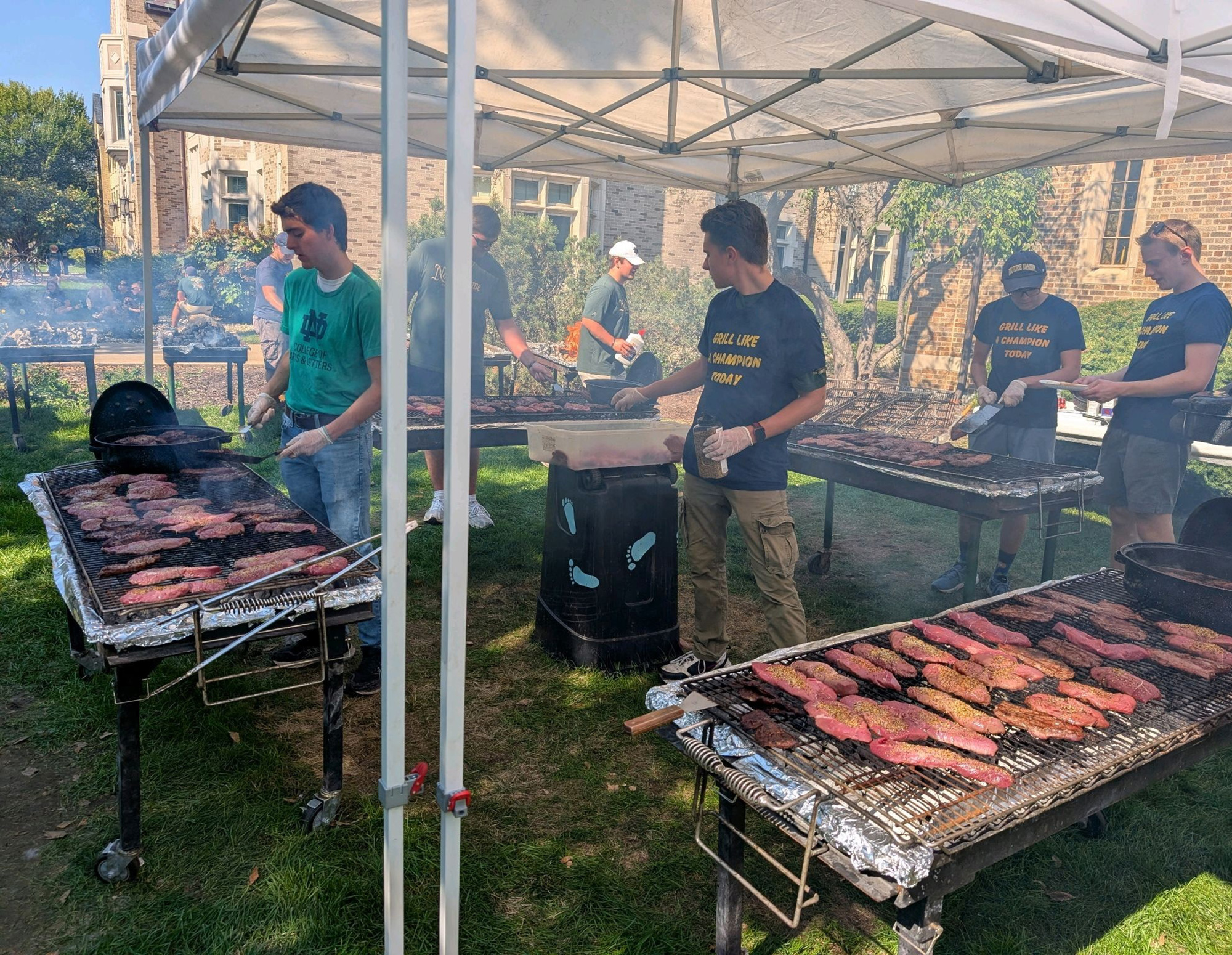 Members of Notre Dame Council 1477 cook steaks.