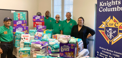 Members of Bishop James C. Burke Council 11285 in Millsboro, Del., and Nina Pierce, a case manager at Catholic Charities Diocese of Wilmington, display diapers and wipes collected during Council 11285’s recent baby supply drive. 