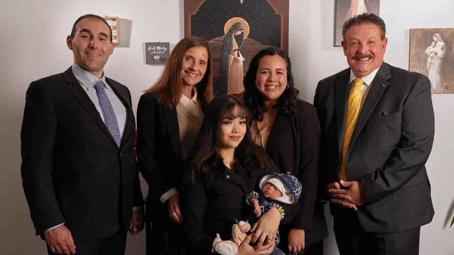 Grand Knight Steven Martinez (right) and David Libertella (left) of St. Timothy Council 12834 share a moment with staff and clients at the Life Center of Santa Ana. (Photo by Slav Zatoka)