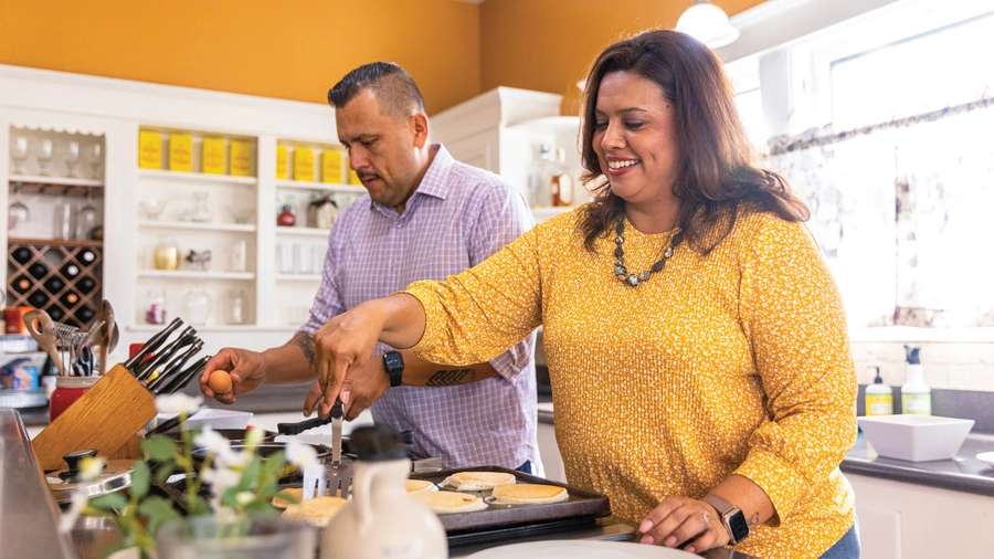 A couple cooks together.