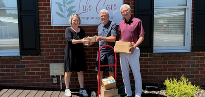 Grand Knight Kent Siefkes (left) and Treasurer Bob Varro of Father Robert T. Lawson Council 11103 in Pinehurst, N.C., present baby bottles filled with more than $14,000 in change to Barbara Lamblin, executive director of Life Care Pregnancy Center. The center received an additional $100 donation from the Supreme Council through the Aid and Support After Pregnancy (ASAP) program. The bottles were donated by parishioners of Sacred Heart Church, and the funds will be used to purchase cribs for the center’s clients.