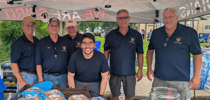 Knights from Iowa Great Lakes Council 5043 in Spirit Lake, Iowa, gather at their food booth during the second day of the annual seven-day bicycle ride across Iowa sponsored by the Des Moines Register. Council 5043 partnered with Dickinson County Cattlemen to grill meals and sold more than 750 burgers, raising approximately $2,200. The funds were given to Zach Steffens, a seminarian for the Diocese of Sioux City, to support his pilgrimage to Italy next year. Steffens is a member of Council 5043 and grew up as a parishioner of St. Mary Catholic Church, which the council serves.