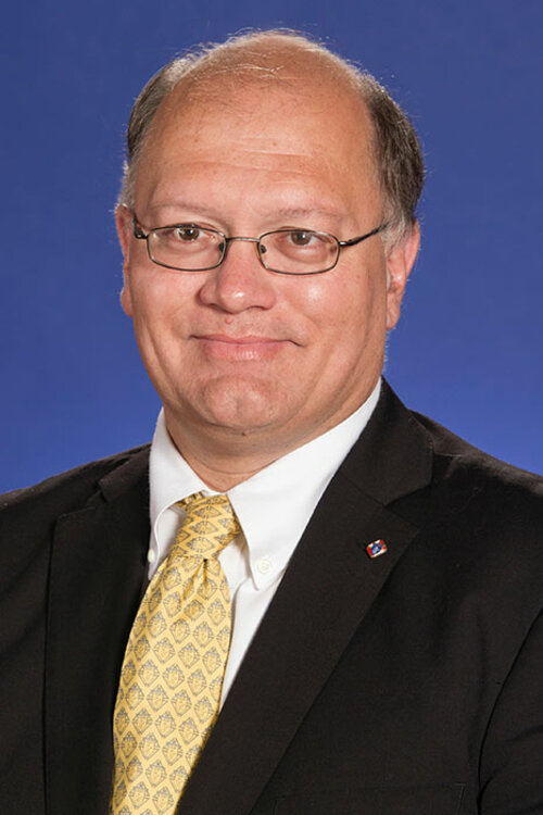 Portrait Of Deputy Supreme Knight Arthur L. Peters smiling in a suit with a Knights of Columbus pin.