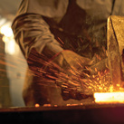A blacksmith hammers a piece of heated metal.