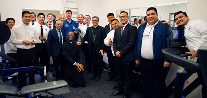 Bishop Alberto Rojas (center) of San Bernardino, Calif., diocesan seminarians and Knights from several local councils gather inside the newly renovated gym at the St. Junipero Serra House of Formation in Grand Terrace after a blessing by Bishop Rojas. Several councils and individual Knights raised $7,500 to support the renovations, which included new exercise equipment. Knights from Grand Terrace Council 12050 helped paint the walls and install new flooring.