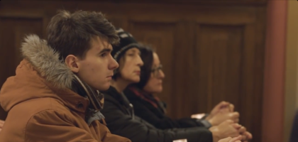 Young man a two women kneel in prayer.