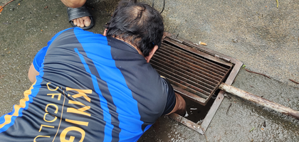 Grand Knight Enrico Bulaong (front) and Romeo Bautista of St. Elizabeth of Hungary Council 16272 in Malolos, Luzon North, unclog a sewer on the grounds of St. Elizabeth of Hungary Parish after a recent storm caused drainage buildup. Five Knights helped clean the grounds over the course of four hours.