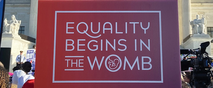 a sign 'Equality Begins in the Womb' in front of the Supreme Court building in Washington D.C.