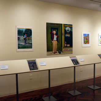 Photo of a museum exhibit interior featuring five magazine cover art paintings. 