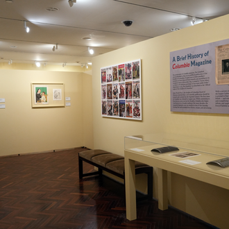 Photo of a museum exhibit interior featuring magazine cover art and printing plates on display. 