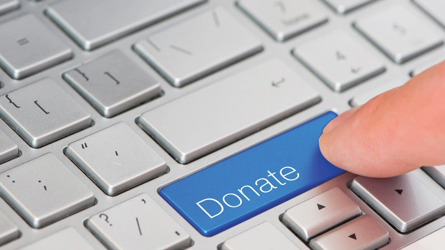 A finger press blue Donate button on laptop keyboard