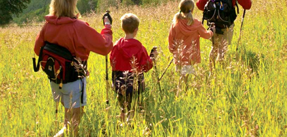 Family hiking through the wilderness with father leading the way.