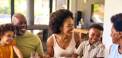 A family sitting down and having a meal together enjoying each other's company.