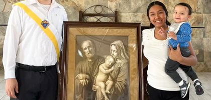 Joel Rodríguez, a member of  Santa Filomena Council 16296 in Monterrey, Mexico Northeast, stands with his wife, Rubí, and their son, Mateo, beside a pilgrim icon of the Holy Family. 