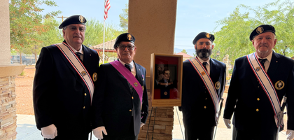 Members of Father Joseph Bochenski Assembly 2532 in Pahrump, Nev., stand by a newly framed portrait of Blessed Michael McGivney displayed outside of Our Lady of the Valley Catholic Church. A member of the assembly coordinated the acquisition of the image and mounted it in the entryway of the church. Father Bruno Mauricci, pastor and a brother Knight, blessed the portrait after a Sunday Mass.