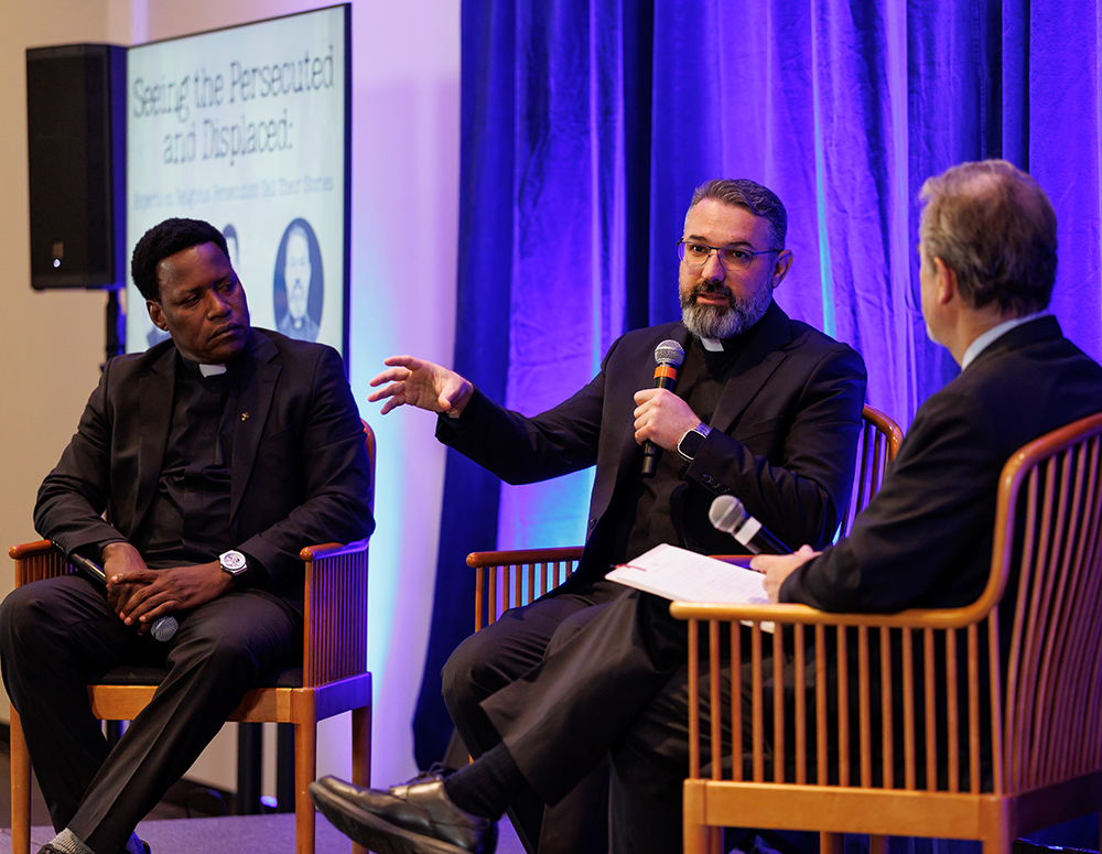 Father Karam Shamasha of Iraq speaks during a panel at the exhibit opening Dec. 2. He is seated between Father Athanasius Barkindo of Nigeria (left) and Christian persecution expert Stephen Rasche. (Photo by Avi Gerver)