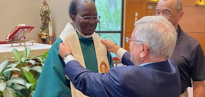 Deputy Grand Knight Steve Gertel of Father Hugon Council 3521 in Tallahassee, Fla., presents Father Semanhyia Boateng-Mensah, parochial vicar at Good Shepherd Parish and a brother Knight, with a stole depicting Blessed Michael McGivney as a retirement gift. The council also gave him a photo book with pictures from his time at the parish.