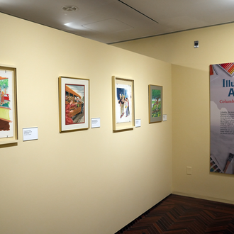 Photo of a museum exhibit interior featuring four magazine cover art paintings and an exhibit text panel.